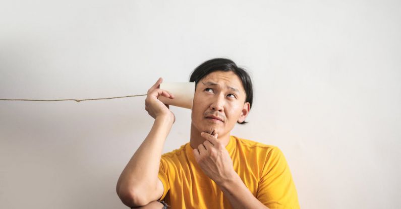 Difficult Conversation - Pensive ethnic man listening to answer in paper cup phone