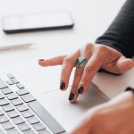 Career Enhancement - Crop female using touchpad on laptop in office