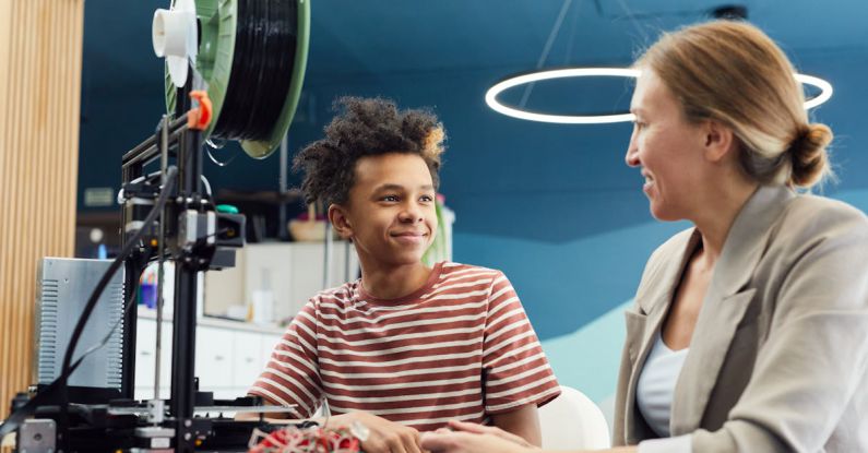 Future Workplace - Positive young male engineer sitting at table with woman and working together on project in light room