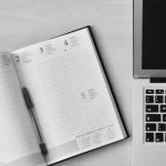 Office Clock - Flat Lay Photography of Unfold Book Beside Macbook
