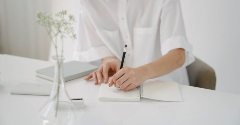 Business Plan Sketch - Crop person writing in notebook at table