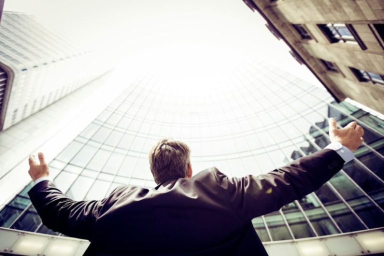 Career - low-angle photography of man in the middle of buidligns