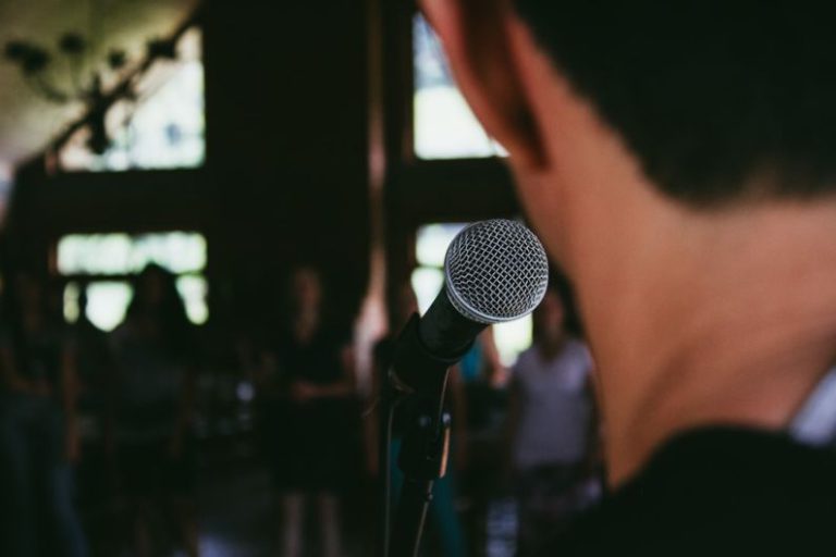 Public Speaking - man standing in front of microphone