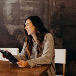 Career - woman sitting around table holding tablet