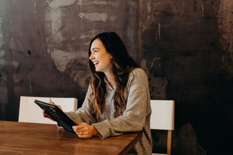 Career - woman sitting around table holding tablet