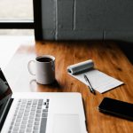 Career - MacBook Pro, white ceramic mug,and black smartphone on table