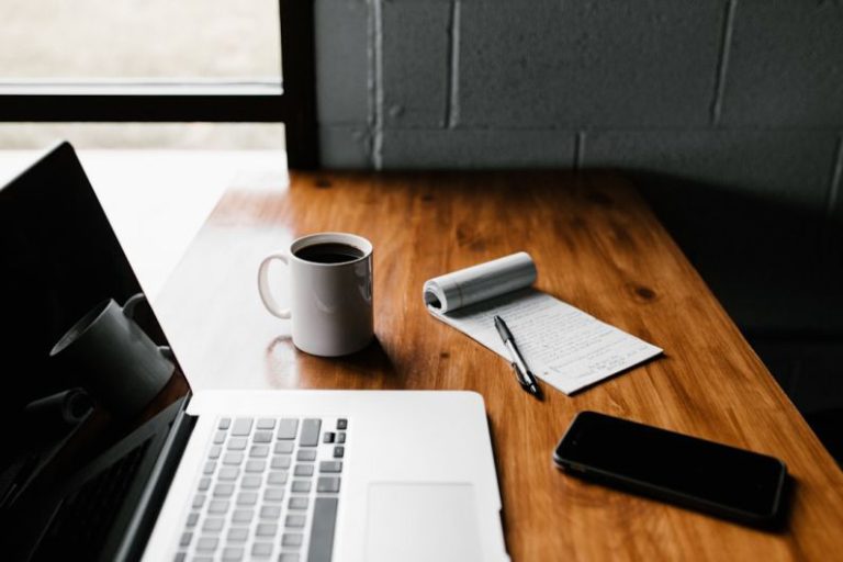 Career - MacBook Pro, white ceramic mug,and black smartphone on table