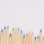 Creativity - colored pencil lined up on top of white surface