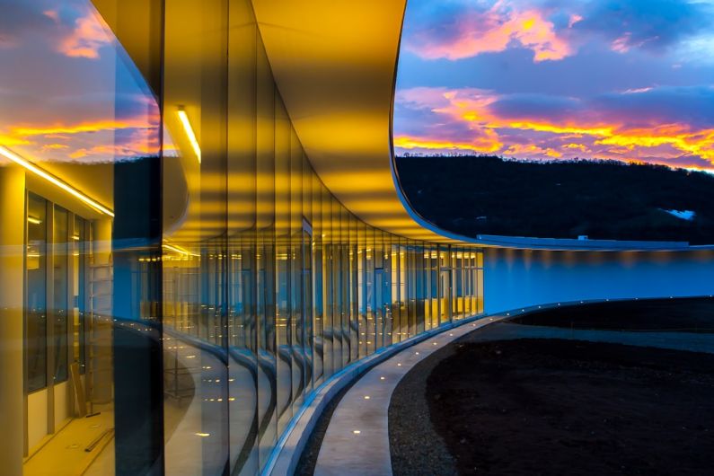 Inovation - clear glass wall building under blue sky with clouds