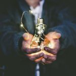 Inovation - man holding incandescent bulb