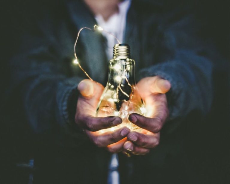 Inovation - man holding incandescent bulb