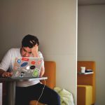 Stress - man wearing white top using MacBook