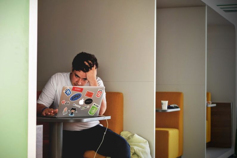 Stress - man wearing white top using MacBook