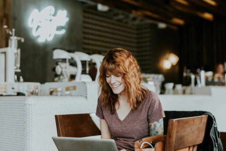 Relax Work - woman sitting on brown wooden chair while using silver laptop computer in room