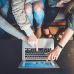 Leadership - three person pointing the silver laptop computer