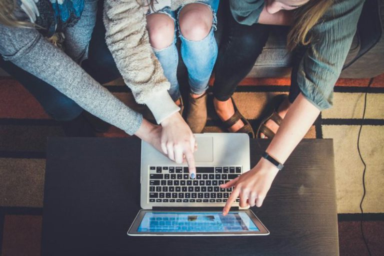 Leadership - three person pointing the silver laptop computer