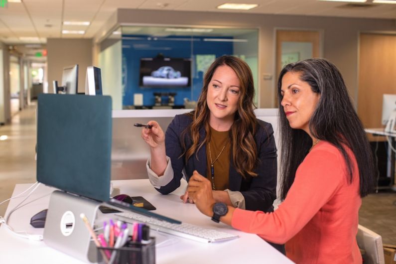 Leadership - two women sitting at a table looking at a computer screen