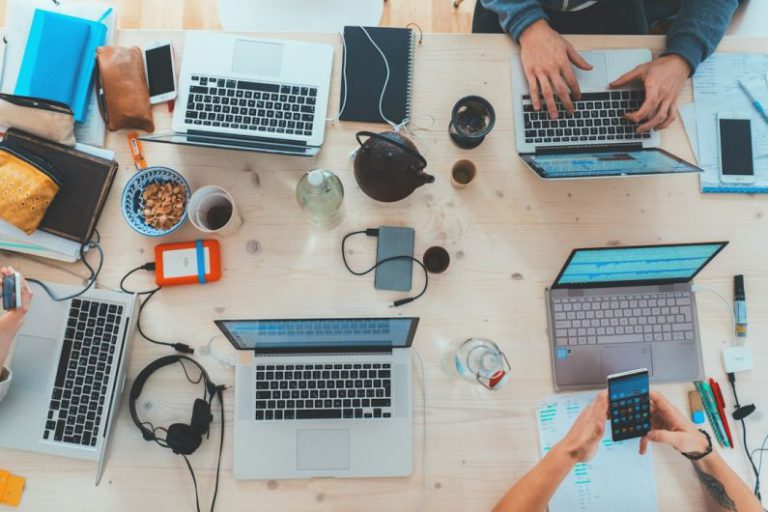 Financial Business - people sitting down near table with assorted laptop computers