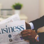 Financial Stability - person wearing suit reading business newspaper