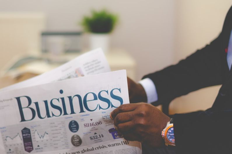 Financial Stability - person wearing suit reading business newspaper
