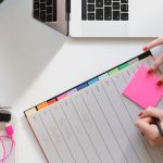 Entrepreneurship - person holding pencil and stick note beside table
