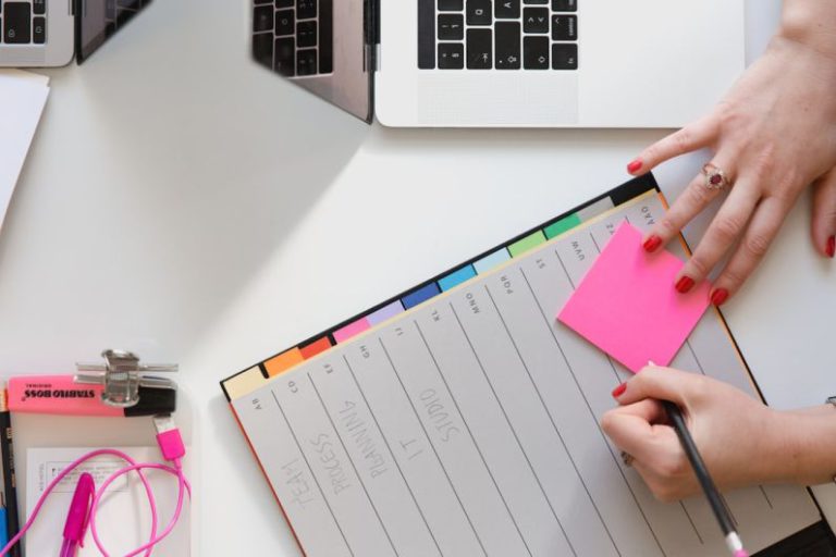 Entrepreneurship - person holding pencil and stick note beside table