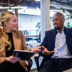 Entrepreneurship - man in black suit jacket sitting beside woman in brown blazer