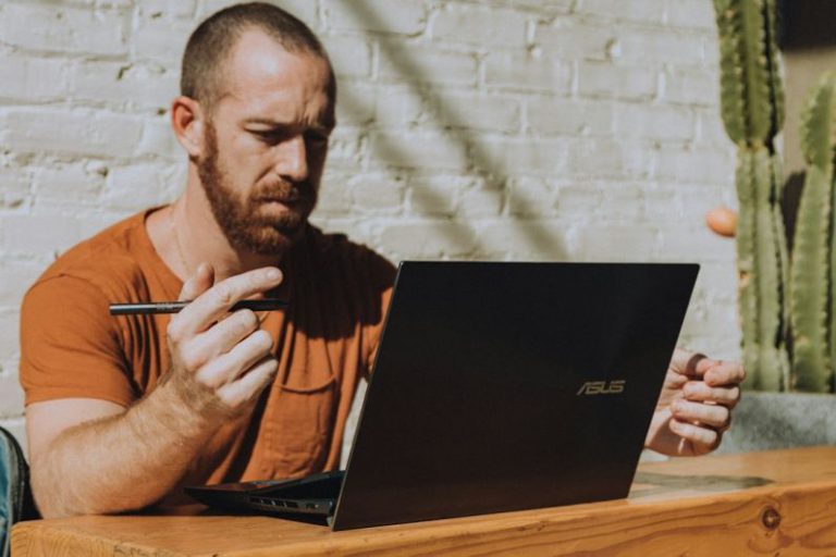 Entrepreneurship - a man sitting at a table using a laptop computer