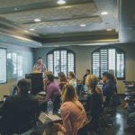 Learning - a group of people in a room with a projector screen