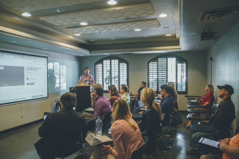 Learning - a group of people in a room with a projector screen