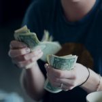 Personal Finance - focus photography of person counting dollar banknotes
