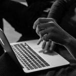 Online - grayscale photo of person using MacBook